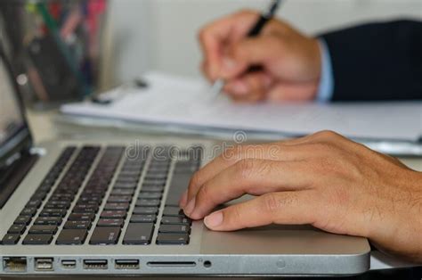 Business Man Hand Typing A Computer And Holding A Pen To Write Business