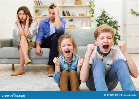 Naughty Children Misbehaving Screaming Sitting Near Exhausted Parents