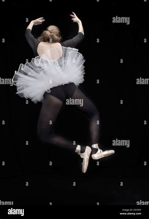 A Ballerina Wearing Black Tights And White Tutu Jumps In The Air