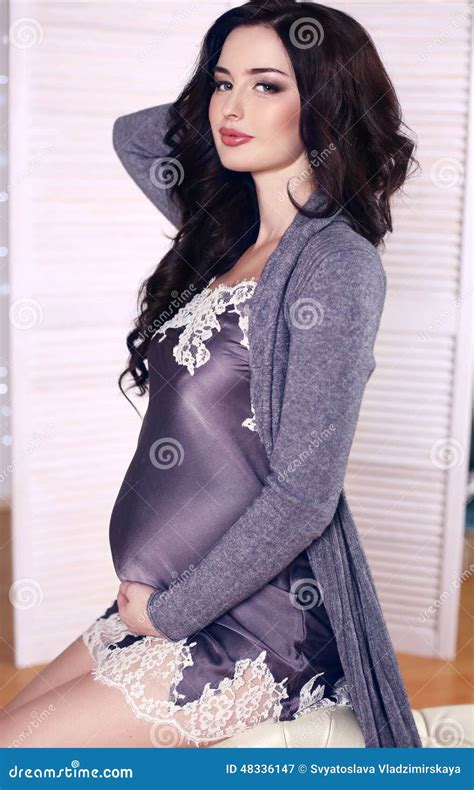 Beautiful Pregnant Woman With Dark Hair Posing In Silk Dress Stock