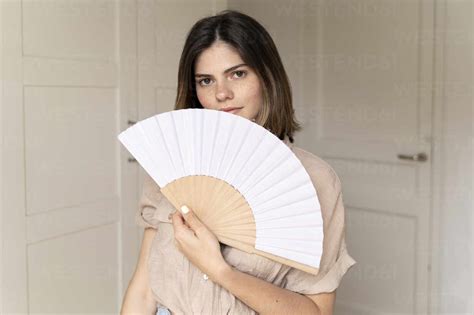 Portrait Of Brunette Young Woman Holding Fan Stock Photo