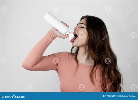 Young Beautiful Woman Putting Whipped Cream Into Mouth On Isolated
