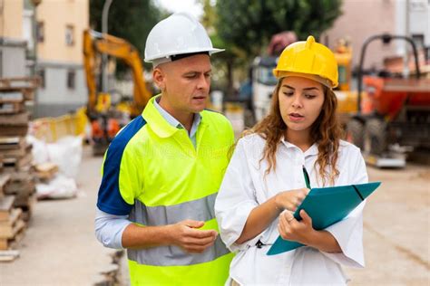 Architect Woman And Foreman Discussing In Construction Site Stock Photo