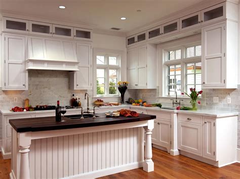 White kitchen cabinets with beadboard doors. This airy kitchen boasts white cabinetry, a white range hood and light brick backsplas ...