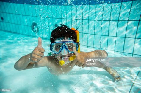 Boy With Diving Goggles And Snorkel Under Water In Swimming Pool High