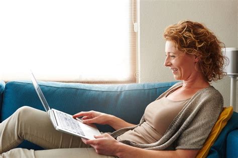 Woman Lying On Sofa With Laptop Smiling Stock Photo Image Of Female