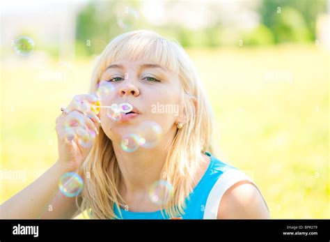 Woman Blowing Bubbles In Park Stock Photo Alamy