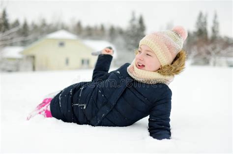Cute Young Girl Having Fun On A Walk In Snow Covered Park On Chilly