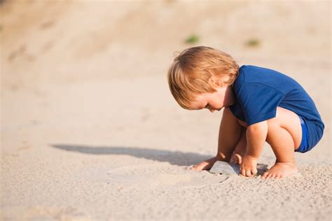 Kleiner Junge Am Strand Der Mit Sand Spielt Kostenlose Foto