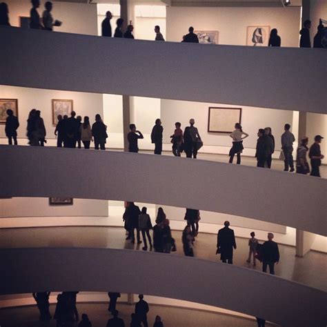 A Group Of People Standing In An Art Gallery
