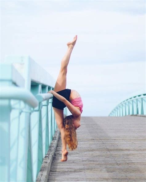 a woman doing a handstand on a pier