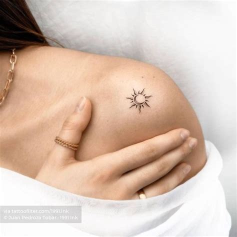 A Woman S Shoulder With A Small Tattoo On Her Left Arm And The Sun In The Middle