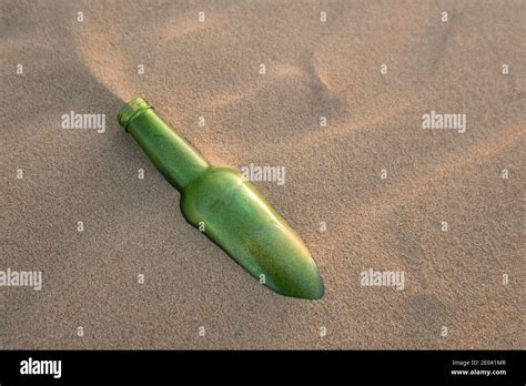 A Bottle Half Buried In The Sand Stock Photo Alamy