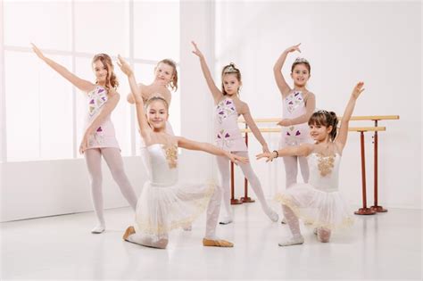 Premium Photo Smiling Little Girls In Dresses Practicing Postures