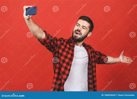 Close Up Portrait Of A Cheerful Bearded Man Taking Selfie Over Red
