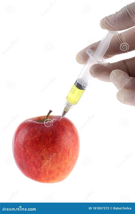 Injection Into An Apple A Hand In A Medical Glove With A Syringe On A
