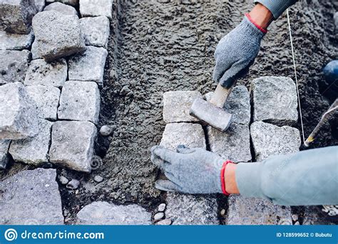 Industrial Worker Installing Pavement Rocks Cobblestone Blocks Stock