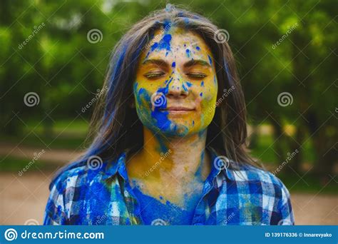 Young Brunette Woman In A Blue Plaid Shirt With Multi Colored Paint On