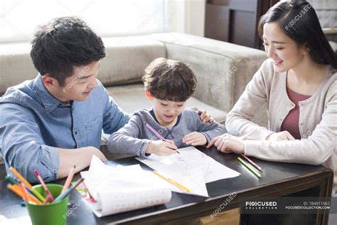 Chinese Parents Helping Son With Homework Backlit Kid Stock Photo