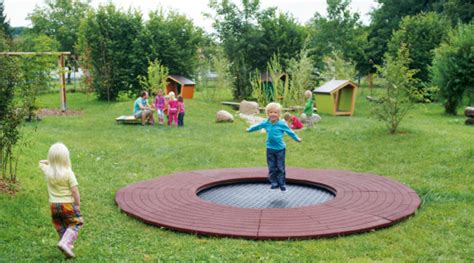 Kleiner Junge springt auf dem Spielplatztrampolin ...