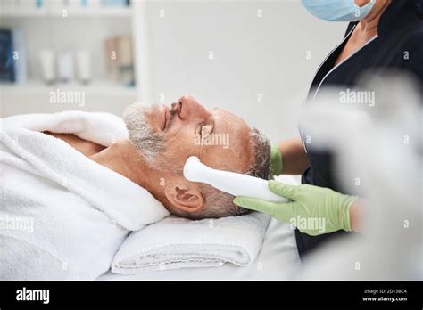 Aging Man Looking Relaxed During Skin Rejuvenation Procedure Stock