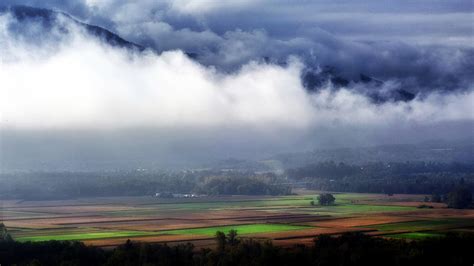 Beautiful Farm And Forest Landscape Under The Clouds In The French Alps