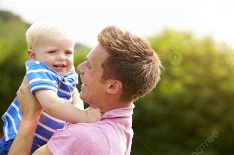 Father Hugging Young Son In Garden Background Together Smiling Year