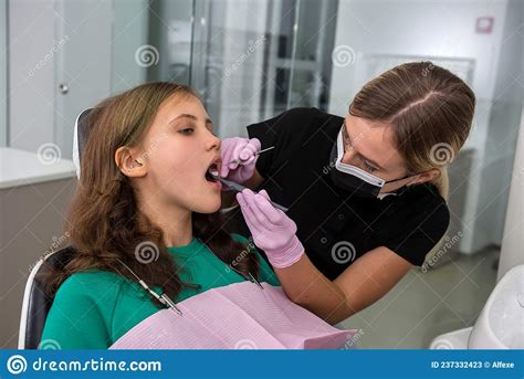 Dentist Treats Caries Tooth Female Patient At Dental Clinic Office