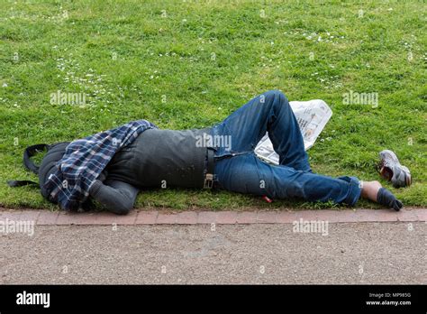 A Drunken Inebriated Man Who Has Fallen Asleep In The Sun On The Grass