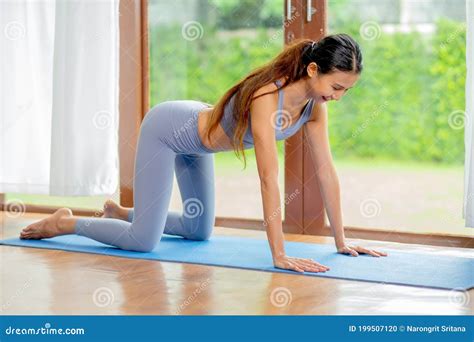 Pretty Asian Girl Action Of Different Yoga Posture In Living Room Of House With Green Garden