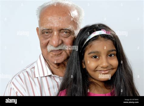 South Asian Indian Grandfather And Granddaughter Looking At Camera MR