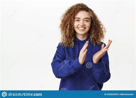 portrait of smiling beautiful curly girl clapping hands and looking pleased praising
