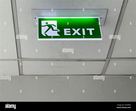 The Green Fire Exit Symbol On The Ceiling Shows Escape Routes Outside