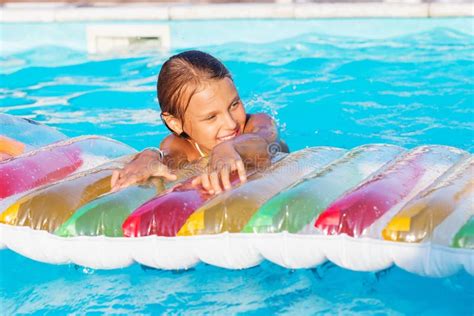 Little Girl Playing And Having Fun In Swimming Pool With Air Mat Stock