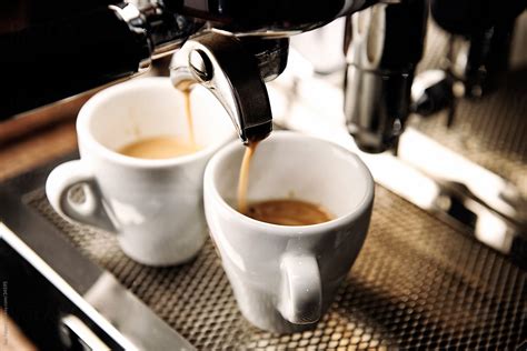 Freshly Brewed Espresso Running Into The Cups By Stocksy Contributor