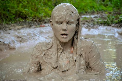 A Woman Is Covered In Mud While Sitting In The Water