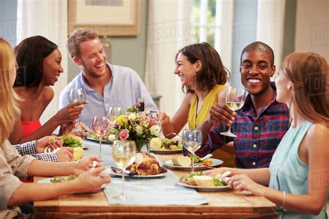 Download and use 40,000+ christmas dinner stock photos for free. Friends At Home Sitting Around Table For Dinner Party ...
