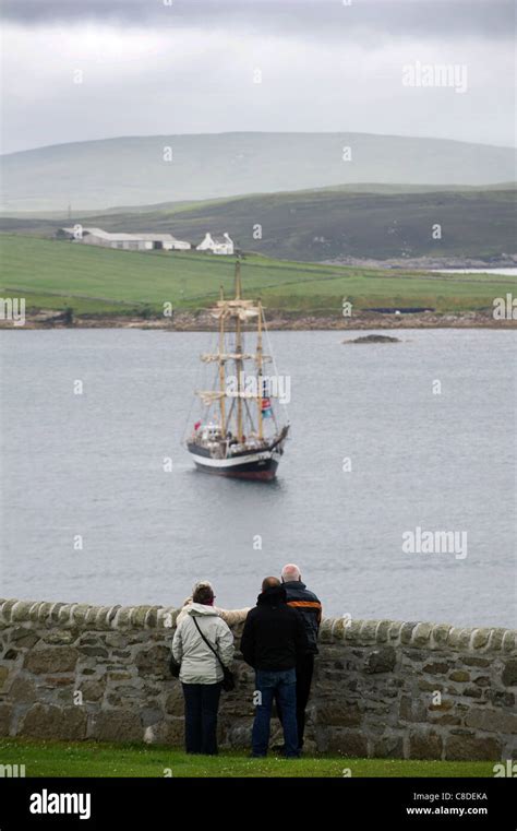 Spectators Watch A Tall Ship Leave Lerwick Harbour On The Shetland