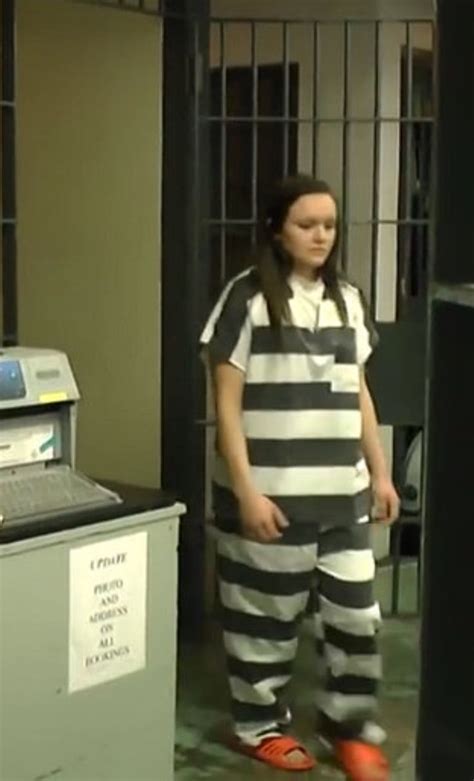 A Woman In Jail Clothes Standing Next To A Machine