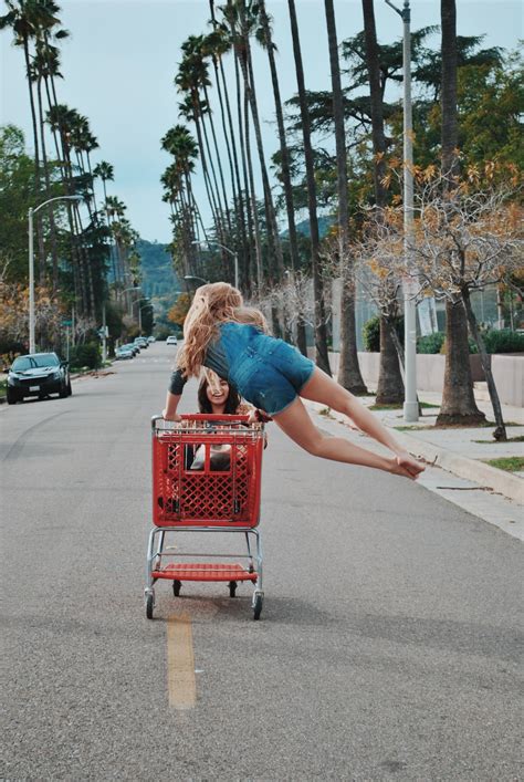 Two Women Riding On Shopping Cart On Road Photo Free Human Image On Unsplash