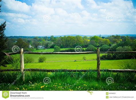 Scenic Rural Landscape Featuring Lush Farmland And Fence In Surr Stock