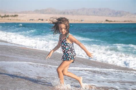 Portrait Of A Cheerful Little Girl In A Bathing Suit By The Sea Stock