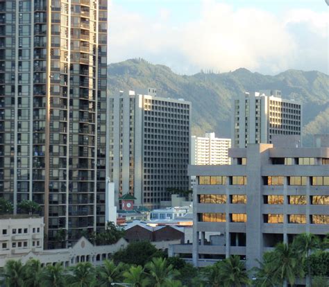 The City Is Surrounded By Tall Buildings And Palm Trees With Mountains