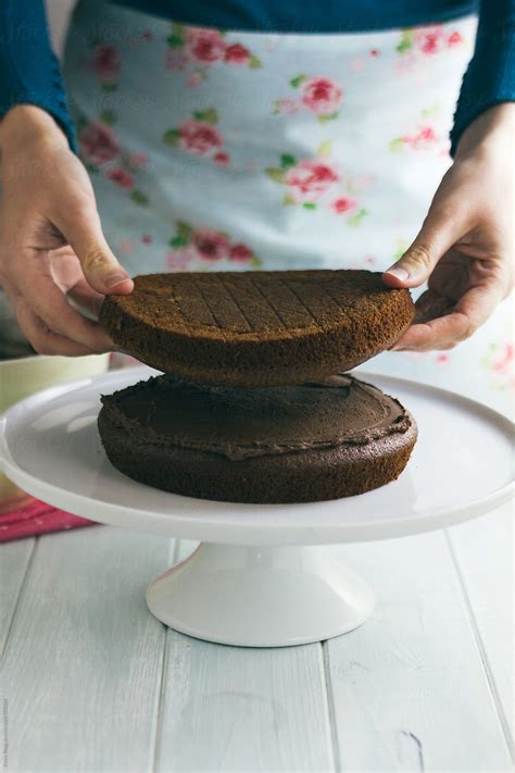 Woman Adding Second Layer To Chocolate Cake By Stocksy Contributor Kirsty Begg Stocksy