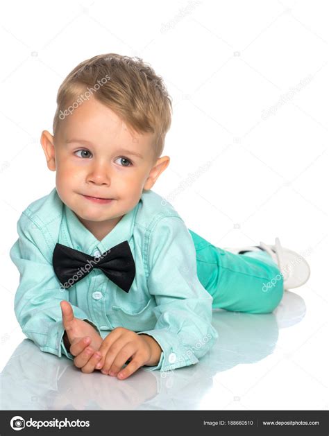 A Little Boy Is Lying On The Floor In The Studio Stock Photo By