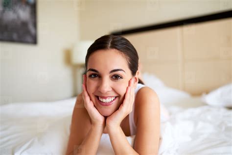 Woman Lying In Bed Resting Chin In Hands Stock Photo 140625