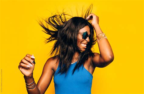 Excited Happy Afro Woman Posing Over Yellow Background Moving Her Hair