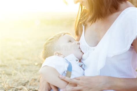 Beautiful Happy Mother Breastfeeding Her Baby Boy Outdoor Stock Photo