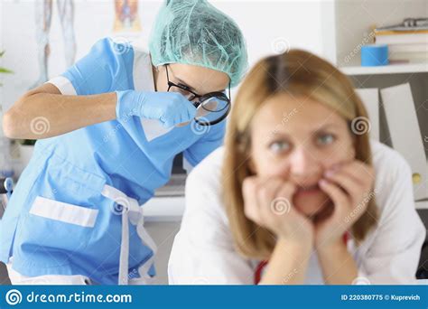 Doctor Examining Woman Rectum With Magnifying Glass In Clinic Stock