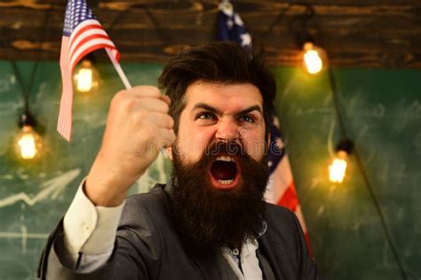 Aggressive Businessman With American Flag And Raised Hand Stock Photo